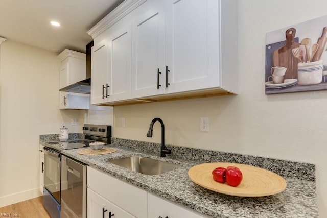 1413 Elm Ave, Portsmouth, VA 23704 - kitchen featuring a sink, appliances with stainless steel finishes, white cabinetry, light wood-style flooring, and light stone countertops