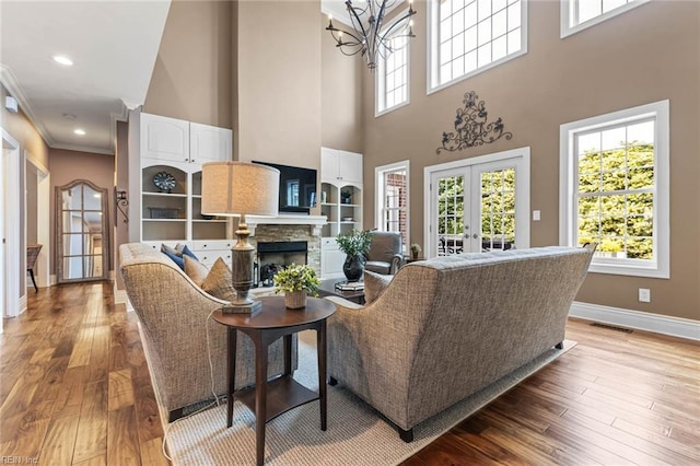 1704 Lower Church Ct, Virginia Beach, VA 23455 - living room with a chandelier, baseboards, light wood-style flooring, a fireplace, and a towering ceiling