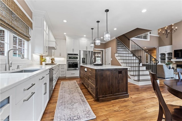 1704 Lower Church Ct, Virginia Beach, VA 23455 - kitchen featuring a sink, white cabinetry, dark brown cabinets, a chandelier, and light wood-style flooring