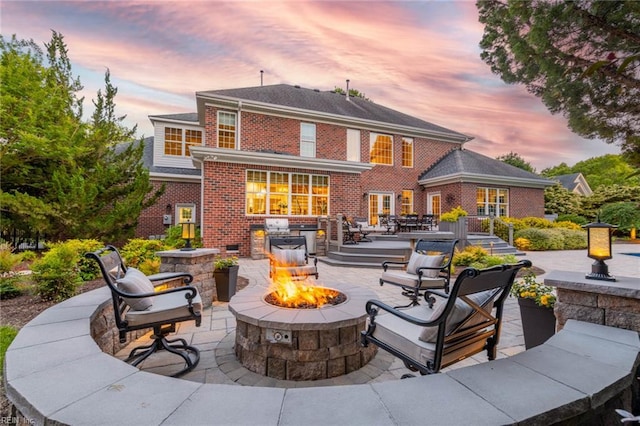 1704 Lower Church Ct, Virginia Beach, VA 23455 - back of house at dusk featuring an outdoor fire pit, brick siding, a patio area, and area for grilling