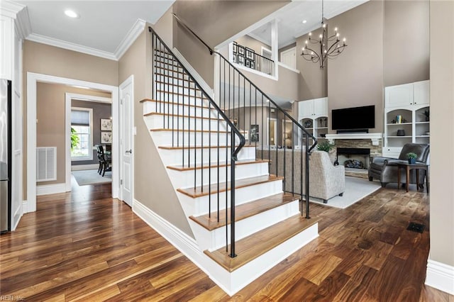 1704 Lower Church Ct, Virginia Beach, VA 23455 - staircase with wood finished floors, a chandelier, baseboards, a stone fireplace, and ornamental molding