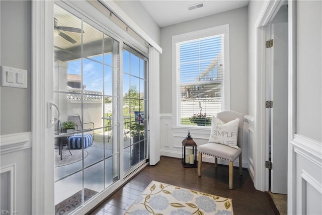 entryway with wainscoting, dark wood finished floors, ceiling fan, and a decorative wall