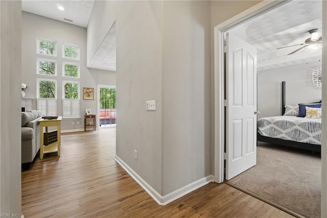 hall with baseboards and wood finished floors