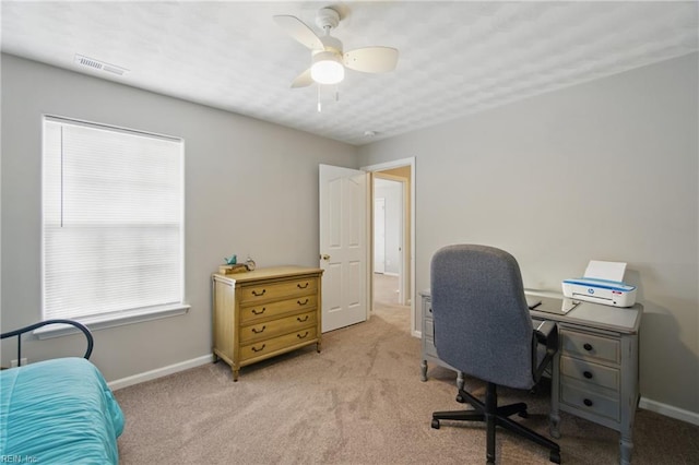 office space with light carpet, baseboards, and a ceiling fan