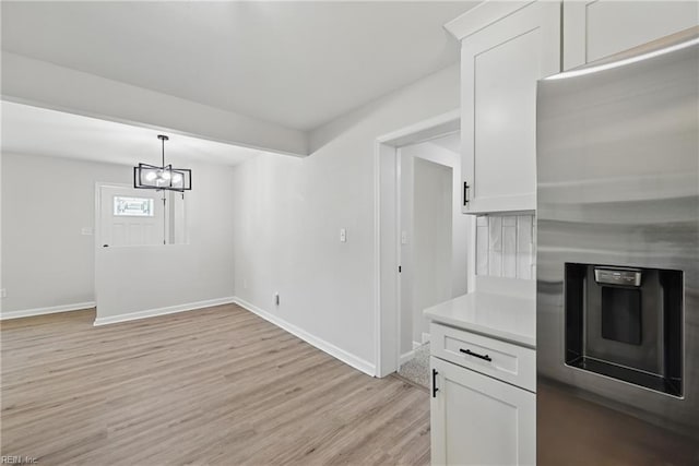 12 Carriage Ln, Newport News, VA 23606 - kitchen featuring stainless steel fridge, light wood-type flooring, baseboards, light countertops, and white cabinets