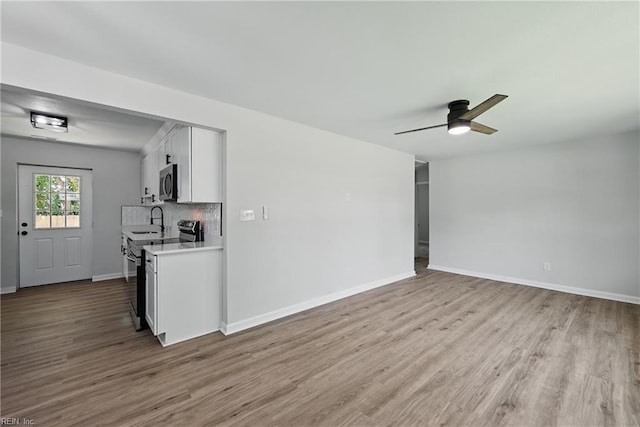 12 Carriage Ln, Newport News, VA 23606 - unfurnished living room featuring wood finished floors, a sink, a ceiling fan, and baseboards
