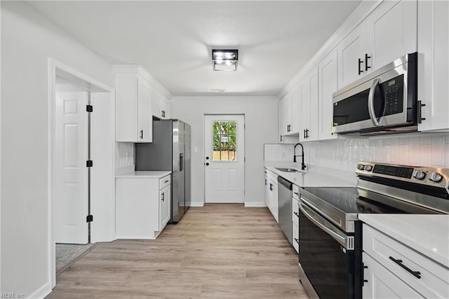 12 Carriage Ln, Newport News, VA 23606 - kitchen featuring stainless steel appliances, a sink, decorative backsplash, light wood-style flooring, and white cabinetry