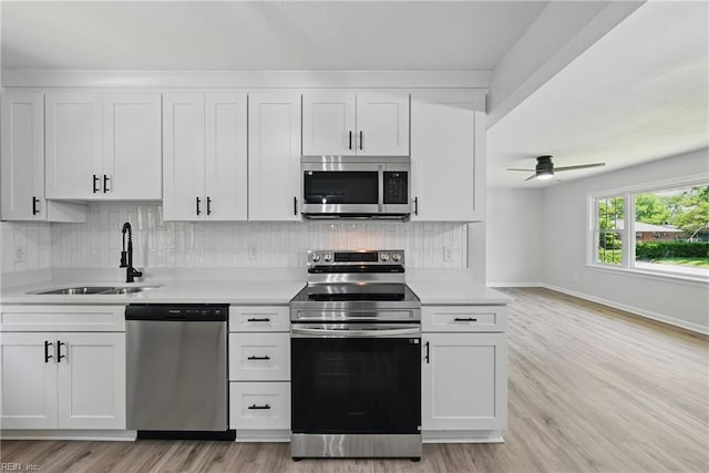12 Carriage Ln, Newport News, VA 23606 - kitchen with stainless steel appliances, a sink, light countertops, white cabinetry, and light wood finished floors