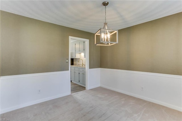 2509 Quail Ridge Ct, Chesapeake, VA 23321 - empty room featuring a chandelier, a sink, light colored carpet, and baseboards