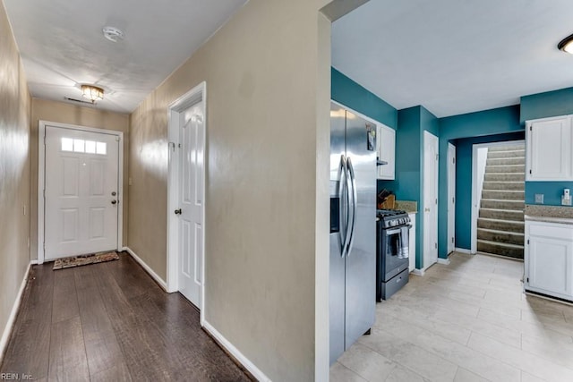1909 Falling Sun Cir, Virginia Beach, VA 23454 - kitchen featuring range with gas stovetop, white cabinets, stainless steel refrigerator with ice dispenser, and baseboards