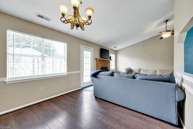 1909 Falling Sun Cir, Virginia Beach, VA 23454 - living room featuring a chandelier, wood finished floors, a textured ceiling, a brick fireplace, and vaulted ceiling