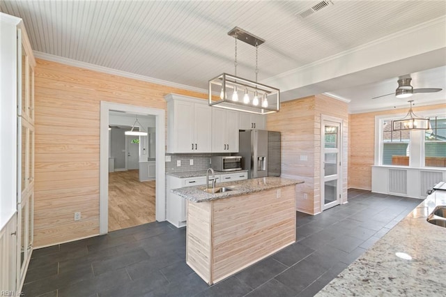 8575 Chesapeake Blvd, Norfolk, VA 23503 - kitchen featuring stainless steel appliances, wooden walls, a sink, a ceiling fan, and light stone countertops