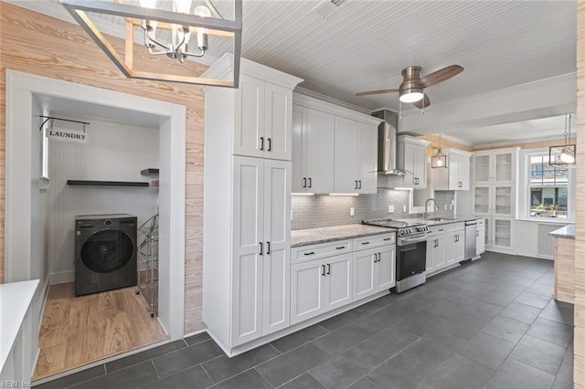 8575 Chesapeake Blvd, Norfolk, VA 23503 - kitchen with appliances with stainless steel finishes, washer / dryer, a sink, wall chimney exhaust hood, and white cabinets
