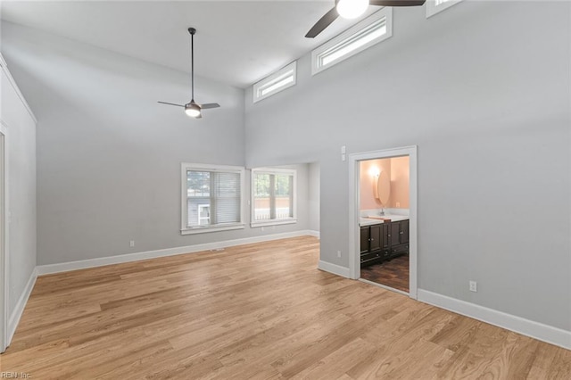 8575 Chesapeake Blvd, Norfolk, VA 23503 - unfurnished living room with ceiling fan, light wood-style floors, a high ceiling, and baseboards