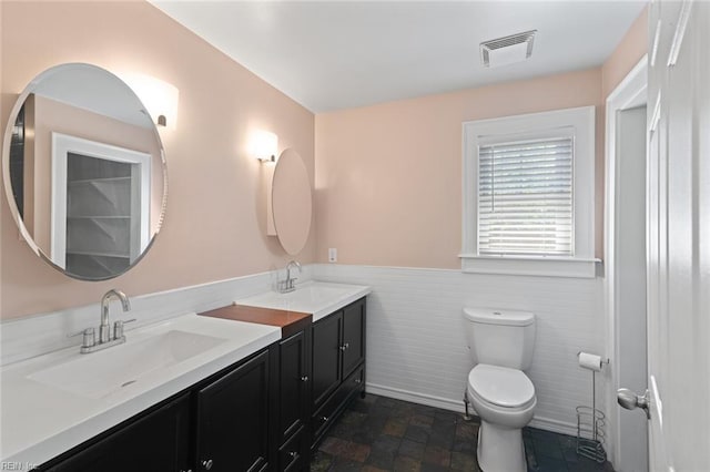 8575 Chesapeake Blvd, Norfolk, VA 23503 - bathroom with toilet, double vanity, a wainscoted wall, stone finish floors, and tile walls