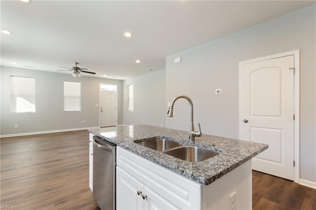 kitchen featuring a sink, stainless steel dishwasher, dark wood finished floors, a ceiling fan, and an island with sink