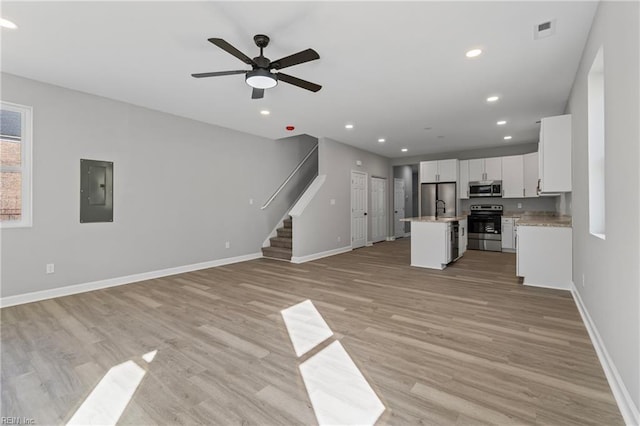 736 A Ave, Norfolk, VA 23504 - unfurnished living room featuring electric panel, stairway, baseboards, light wood-style flooring, and a ceiling fan