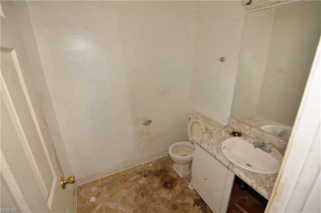 half bath with vanity, toilet, and baseboards