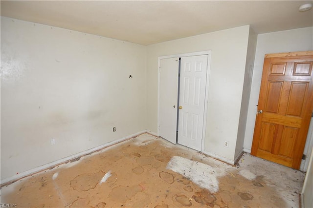unfurnished bedroom with a closet and baseboards