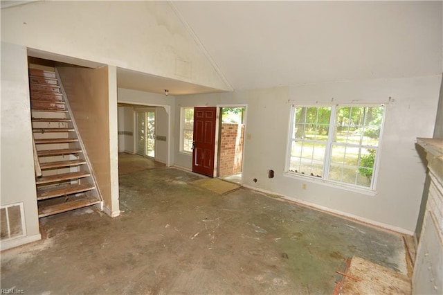 entryway with stairway, lofted ceiling, and baseboards