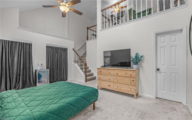 carpeted bedroom with high vaulted ceiling, a ceiling fan, and baseboards