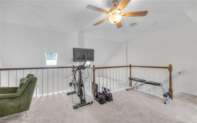 exercise room featuring ceiling fan, a skylight, carpet floors, and baseboards