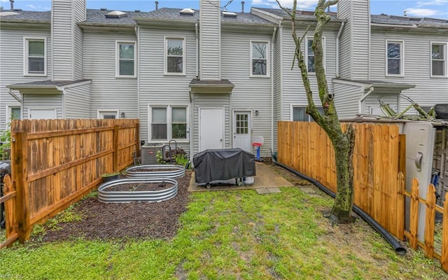 back of house with a vegetable garden and a chimney