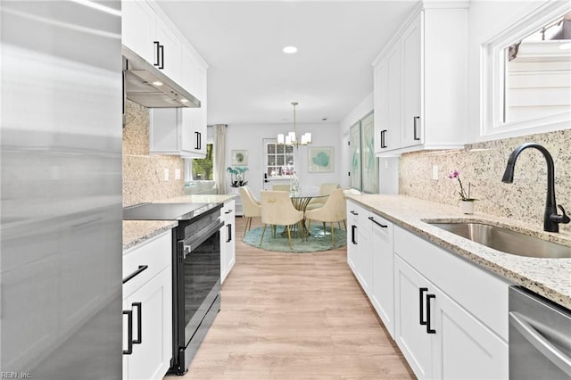 kitchen featuring appliances with stainless steel finishes, a sink, white cabinetry, a chandelier, and recessed lighting
