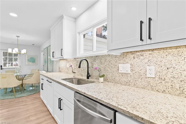 kitchen featuring stainless steel dishwasher, white cabinets, a sink, light stone countertops, and recessed lighting