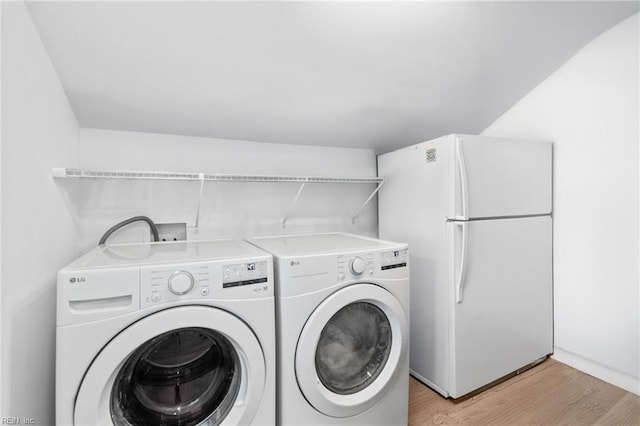 laundry room with washer and dryer and light wood finished floors