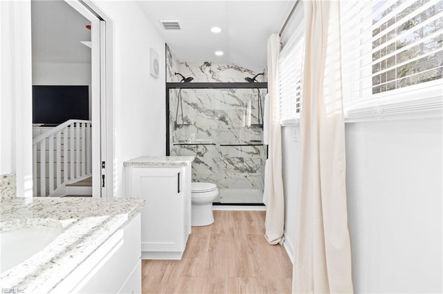 full bathroom with vanity, a marble finish shower, wood finished floors, recessed lighting, and toilet