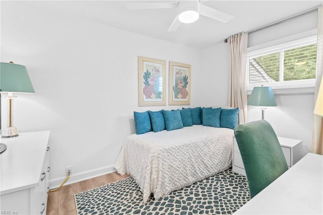 bedroom with light wood-style flooring, baseboards, and ceiling fan