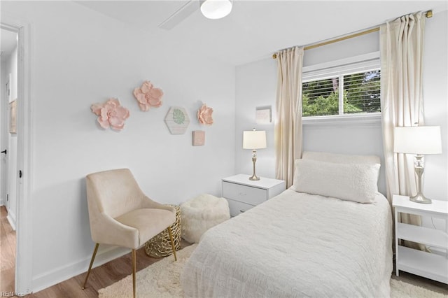 bedroom featuring wood finished floors, baseboards, and ceiling fan