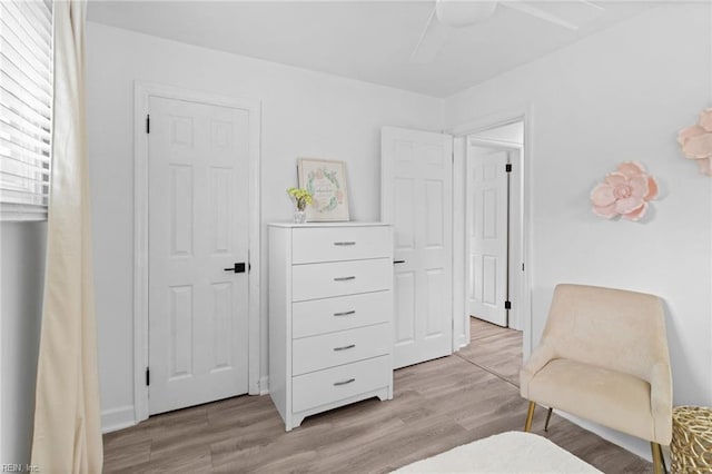 living area featuring light wood-type flooring and a ceiling fan