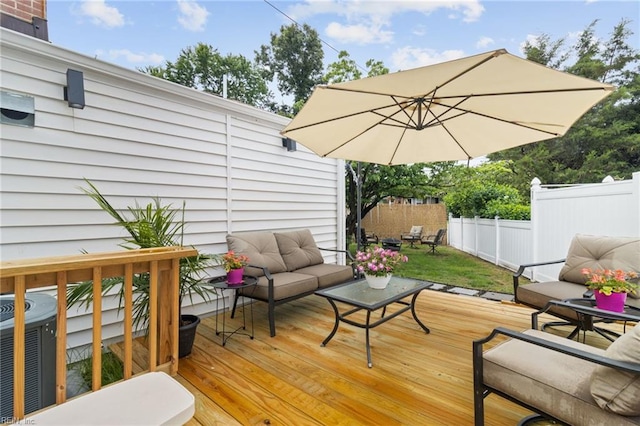 wooden deck featuring an outdoor living space, fence, and cooling unit