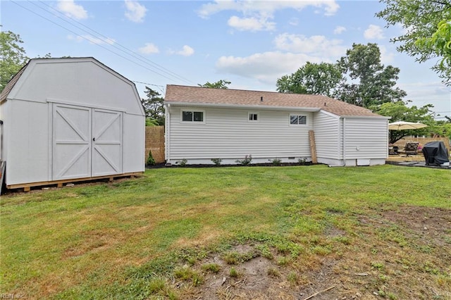 rear view of property with a storage unit, an outdoor structure, and crawl space