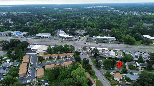 aerial view of property and surrounding area with a heavily wooded area