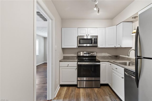7716 Newport Ave, Norfolk, VA 23505 - kitchen featuring stainless steel appliances, a sink, white cabinetry, and dark wood-style floors