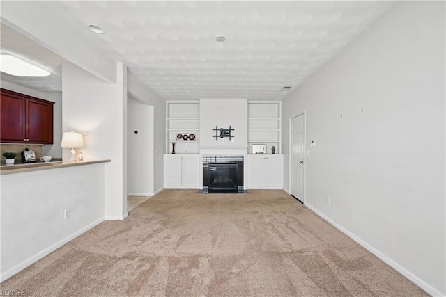 2043 Queens Point Dr, Suffolk, VA 23434 - unfurnished living room featuring light colored carpet, a fireplace with flush hearth, baseboards, and built in shelves