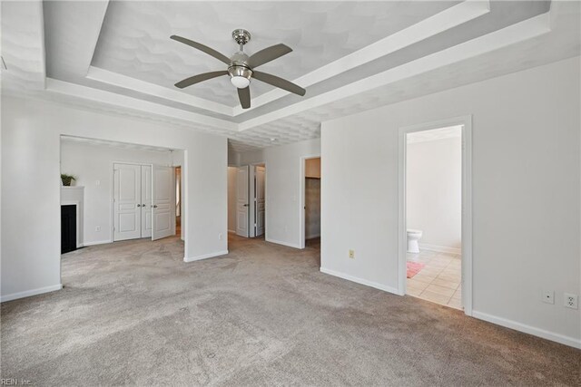 2043 Queens Point Dr, Suffolk, VA 23434 - unfurnished bedroom featuring a tray ceiling, carpet flooring, a fireplace with flush hearth, baseboards, and ensuite bathroom