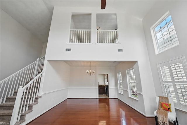 2043 Queens Point Dr, Suffolk, VA 23434 - unfurnished living room featuring high vaulted ceiling, wood finished floors, a chandelier, stairs, and ceiling fan