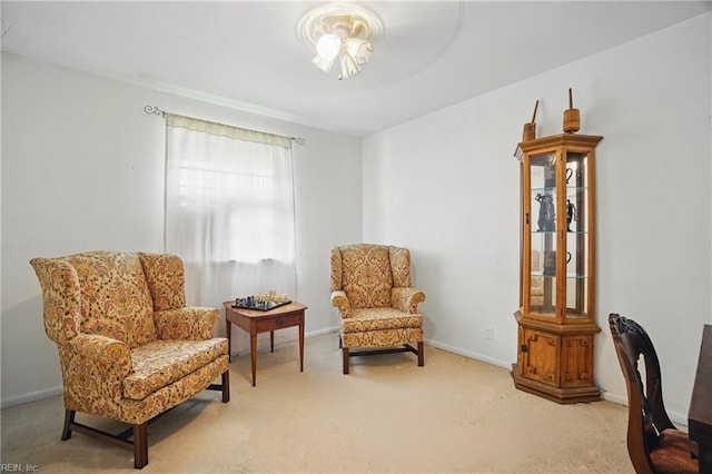 sitting room featuring carpet flooring and baseboards