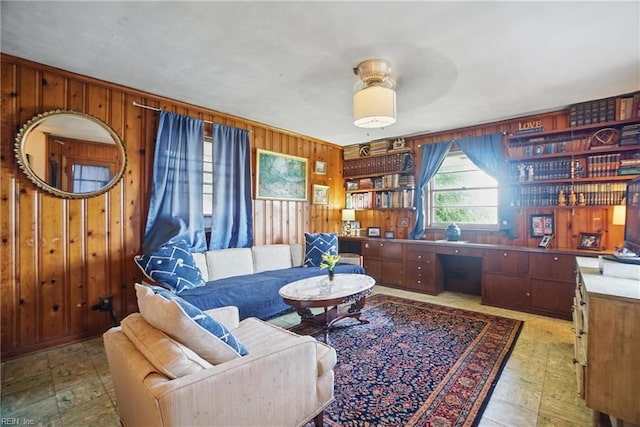 living area featuring wooden walls and a ceiling fan