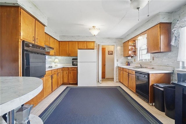 kitchen with black appliances, light countertops, and brown cabinetry