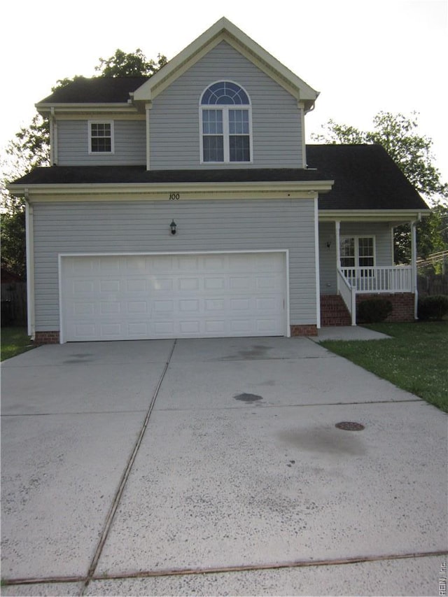 traditional-style home featuring covered porch, driveway, and an attached garage