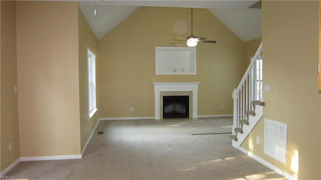 unfurnished living room featuring carpet floors, a fireplace, baseboards, ceiling fan, and stairway