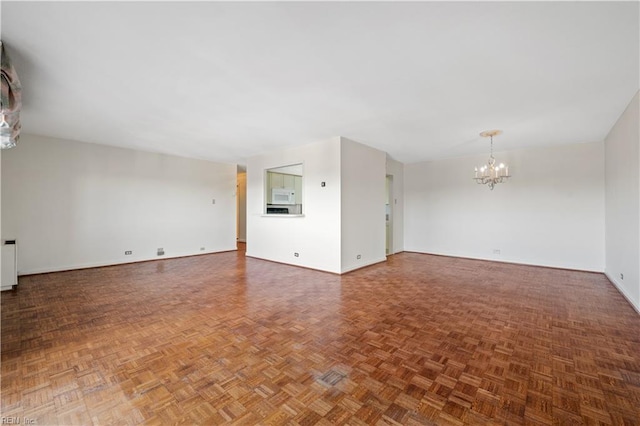 7320 Glenroie Ave Unit 8E, Norfolk, VA 23505 - unfurnished living room featuring a chandelier and baseboards