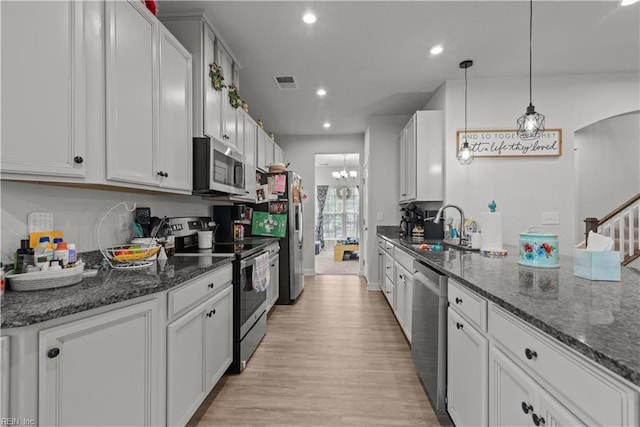 954 Olmstead St, Chesapeake, VA 23323 - kitchen featuring appliances with stainless steel finishes, a sink, light wood-style flooring, a chandelier, and dark stone countertops