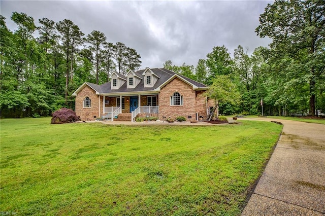 1813 Taft Rd, Chesapeake, VA 23322 - cape cod-style house with covered porch, brick siding, a front yard, and view of wooded area