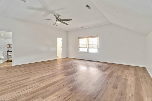 spare room featuring a ceiling fan, light wood-type flooring, baseboards, and vaulted ceiling